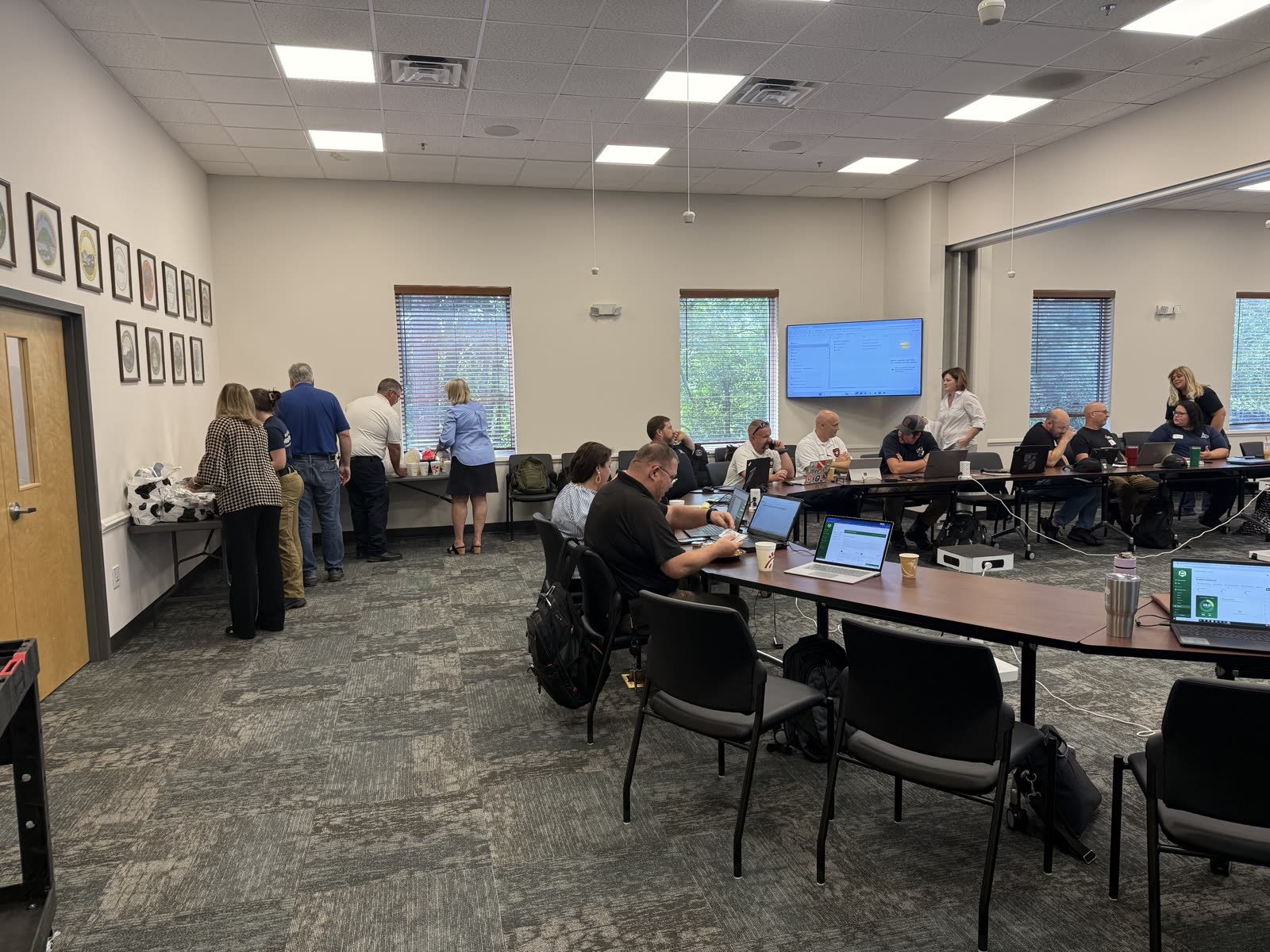 Participants gathered around laptops during the Asheville Beehive training session